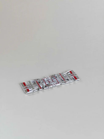 sidovy som visar profil och design av Tesla Plaid Emblem/Badge Silver – TESLA